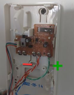 Intercom circuit board with visible wiring and + and - markings.