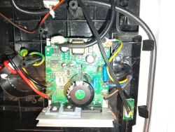 Wnętrze obudowy z płytką PCB, przewodami i elementami elektronicznymi, w tym dużym kondensatorem.