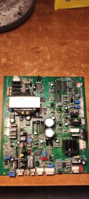 Płytka PCB z licznymi komponentami elektronicznymi na drewnianym blacie