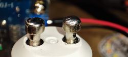 Close-Up of GU10 Bulb Metal Pins Close-up of two metal pins on a white GU10 bulb casing.