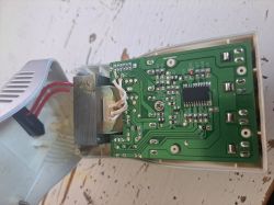 Rozłożona ładowarka akumulatorów z widoczną płytą elektroniczną i okablowaniem.