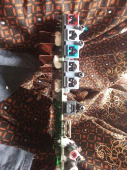 Side panel of a motherboard with network, audio and video ports against a patterned fabric background.