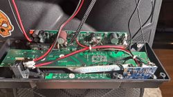 Wnętrze obudowy z płytkami elektronicznymi i kablami.