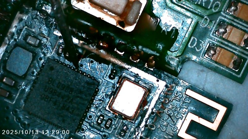 Close-up of damaged integrated circuit with visible tracks and burn marks