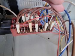 Zbliżenie na panel połączeń elektrycznych z przewodami o różnych kolorach.