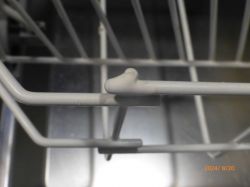 Zbliżenie na pręt kosza zmywarki z widoczną naprawą powłoki ochronnej.