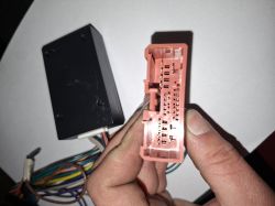 Zbliżenie na różową wielopinową wtyczkę instalacji radia trzymaną w dłoni
