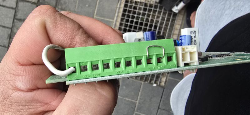 Zielona listwa zaciskowa na płytce, z opisami 24, IP00 i CLA, trzymana w dłoni.