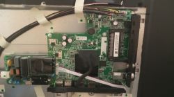 Płyta główna telewizora SHARP wewnątrz obudowy Wnętrze telewizora: zielona płyta główna z radiatorami, złączami i przewodami