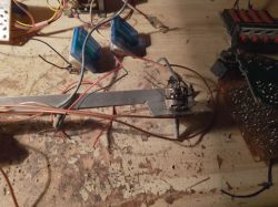 Elementy elektroniczne i przewody na zagraconym stole warsztatowym
