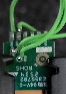 Close-up of green wires soldered to a small printed circuit board