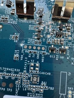 Close-up of a motherboard with visible electronic components and UART test points.