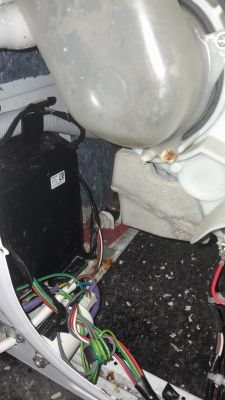 Zdjęcie wnętrza pralko-suszarki Beko, widoczne przewody i elementy mechaniczne.