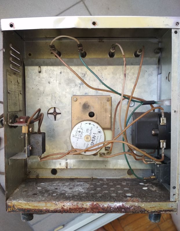 Wnętrze starego opiekacza Predom Selfa z widocznymi przewodami, zegarem mechanicznym i elementami elektrycznymi.