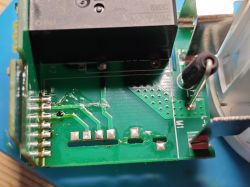 Close-up of BroadLink PCB with relay, capacitor, pin header and visible soldering marks.