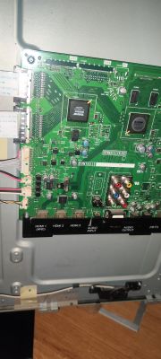 Płyta główna telewizora z widocznymi złączami HDMI i elementami elektronicznymi.