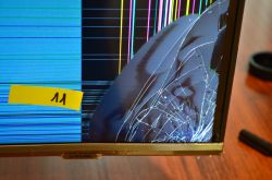 Uszkodzony ekran telewizora Samsung z pęknięciami i kolorowymi liniami.