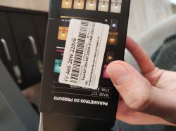 A person holds a black LED bulb box labeled with a TY-A60-20W-220VB product sticker.