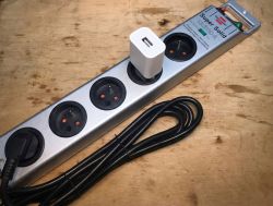 Listwa zasilająca Super Solid 3500A z białą ładowarką USB w gnieździe, na drewnianym blacie