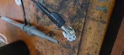 Oscilloscope probe connected to an LED on a wooden workbench