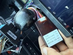 Zbliżenie na instalację radia w BMW z widocznymi przewodami i modułem CAN BUS