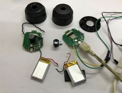 Two disassembled cameras with circuit boards, batteries, lenses, cables, and casings on a white background.