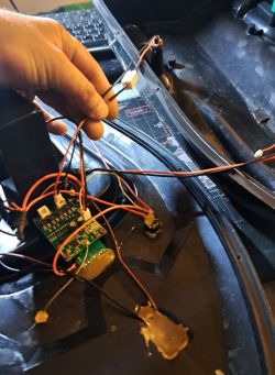 Wnętrze łódki zanętowej z odsłoniętą elektroniką i przewodami