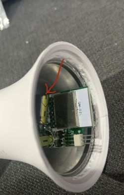 The inside of a bulb with electronic components and a highlighted capacitor.