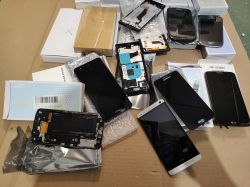 Różne ekrany i części do smartfonów ułożone na kartonie