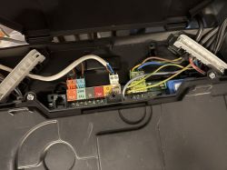 Widok wnętrza skrzynki elektrycznej z kolorowymi złączami i przewodami.