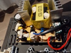 Close-up of a speaker power supply circuit board with electronic components and heat sinks.