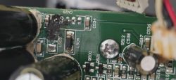Uszkodzony obszar płytki PCB z wypaloną ścieżką i brakującymi komponentami L503 i C533
