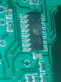 Burnt part of a converter on a circuit board with blurred markings.