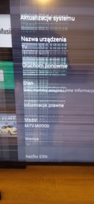 Ekran telewizora Redmi z pionowymi paskami i rozmytym obrazem menu systemowego.