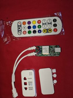 Remote control, LED controller, and casing parts on a red background.