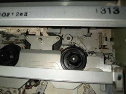 Wnętrze magnetowidu Funai V-3EE, widoczny mechanizm z kołami zębatymi i częściowo zamontowanymi elementami.