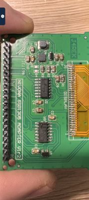 Green printed circuit board with various electronic components.