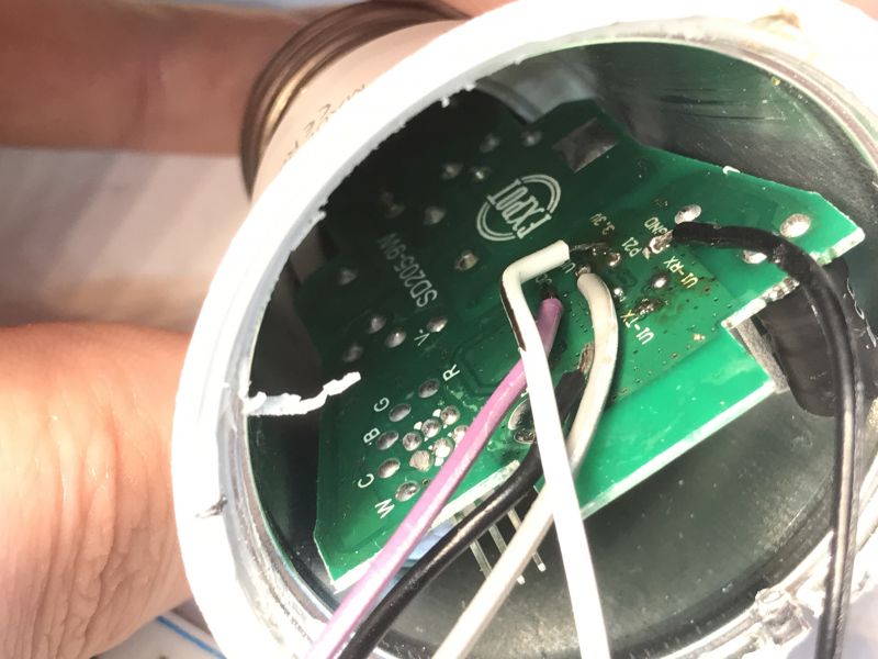 Inside View of TNCE Smart E27 Bulb with Circuit Board Inside view of a light bulb with visible circuit board and wires.