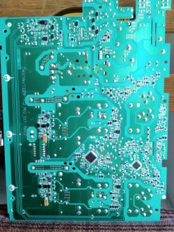 Zbliżenie na płytę drukowaną z widocznymi ścieżkami i komponentami elektronicznymi.