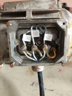 Wnętrze skrzynki przyłączeniowej silnika elektrycznego z wyraźnie oznaczonymi przewodami U2, V2, W2 połączonymi w konfiguracji trójkąta.