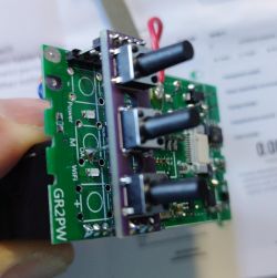 Close-up of a GR2PW electronic device circuit board with three switches.