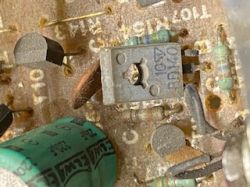 Zbliżenie brudnego układu elektronicznego z tranzystorem BD136 i zielonym kondensatorem UNITRA