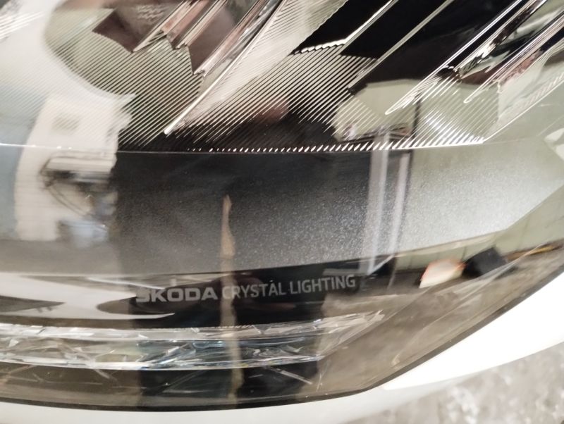 Zbliżenie na przednią lampę LED samochodu z napisem „Skoda Crystal Lighting” na kloszu.