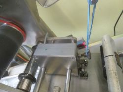 Urządzenie do etykietowania z czujnikiem i mechanizmem przesuwającym etykiety.