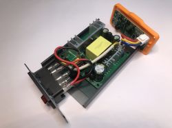 Wnętrze otwartej stacji lutowniczej, widoczne elementy zasilacza impulsowego, przewody i płytka PCB.