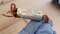 Zużyty kondensator metalizowany z pięcioma przewodami, oznaczony m.in. 0,1uF i 2x2500pF.