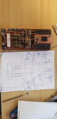 Zdjęcie układu elektronicznego z rysunkiem schematu elektrycznego obok.