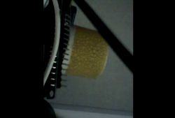 Yellow air filter mounted in a plastic housing with visible ribbing