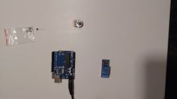 Podzespoły elektroniczne: płytka Arduino, przekaźnik, potencjometr, bateria guzikowa i tranzystor.