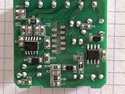 PCB with two IC chips, visible traces, resistors, and labeled components on grid background.